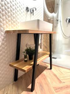 ein Badezimmer mit einem weißen Waschbecken auf einem Holztisch in der Unterkunft Apartamenty Homole in Szczawnica