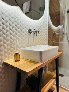 ein Badezimmer mit einem weißen Waschbecken und einer Dusche in der Unterkunft Apartamenty Homole in Szczawnica