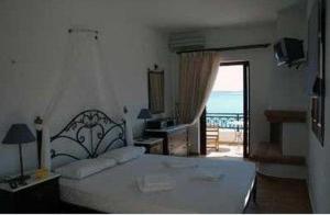 a bedroom with a bed and a view of the ocean at Kekrifalia Hotel in Skala