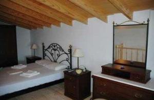 a bedroom with a bed with a dresser and a mirror at Kekrifalia Hotel in Skala