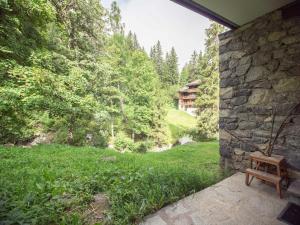 a stone house with a bench on a patio at Studio-cabine au pied des pistes avec terrasse de plain-pied in Valmorel