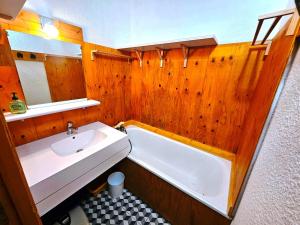 a bathroom with a tub and a sink and a bath tub at Studio-cabine au pied des pistes avec terrasse de plain-pied in Valmorel +38 photos