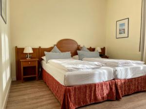 two beds in a hotel room with at Hotel Angerbräu in Murnau am Staffelsee +35 photos