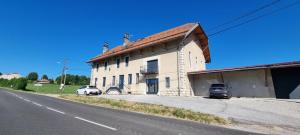 a large white building on the side of a road at Appartement neuf et confortable dans le Haut Jura in Lac des Rouges Truites
