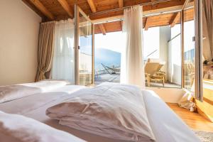 a bedroom with two beds and a large window at Superior Sport und Familienresort Alpenblick in Zell am See