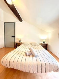 a bedroom with a large bed with two pillows on it at Calme et confort tout équipé au cœur de Moirans in Moirans