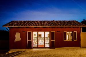 ein rotes Haus mit offener Tür davor in der Unterkunft Le Stanze Della Musica in Borgomale