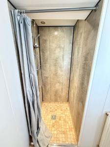 a shower with a shower curtain in a bathroom at Calme et confort tout équipé au cœur de Moirans in Moirans +6 photos
