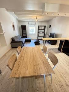 a living room with a wooden table and a couch at Calme et confort tout équipé au cœur de Moirans in Moirans