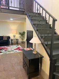 a living room with a staircase and a table with a lamp at Grand Studio 56 in Faro