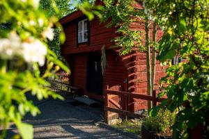 a wooden cabin with a fence in front of it at Härbre Cabin in Årjäng