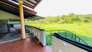 a balcony of a house with a view of a field at southern grace apartment in Unawatuna