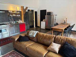 a living room with a brown couch and a kitchen at Achterhuis Echt mooi in Nijeveen