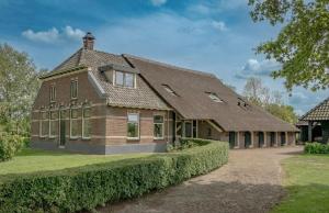 a large brick house with a roof at Achterhuis Echt mooi in Nijeveen