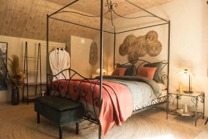 a bedroom with a canopy bed and a chair at Chambres Ardennez-vous in Saint-Hubert