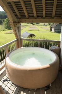 a hot tub on a deck with a roof at Suite de charme in Saint-Hubert