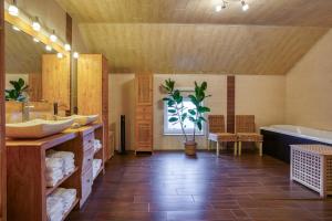 a bathroom with two sinks and a tub and a plant at Chambres Ardennez-vous in Saint-Hubert