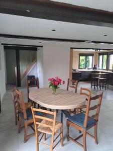 a wooden table with chairs and a vase of flowers on it at Lajufe in Cormeilles +20 photos