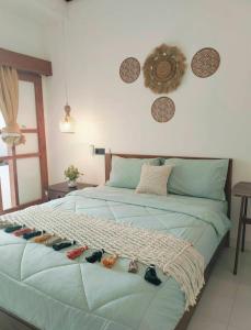a bedroom with a bed with shoes on it at Bali Guesthouse in Uluwatu