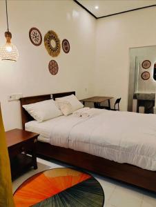 a bedroom with a bed and a table and plates on the wall at Bali Guesthouse in Uluwatu