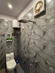 a bathroom with a white toilet and a marble wall at Tropical vibes Private, Terrace, Cozy space- Gurgaon and NCR in Gurgaon +71 photos
