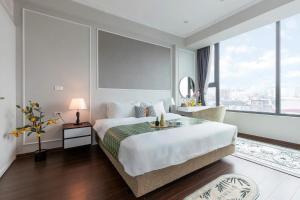 een slaapkamer met een groot bed en een groot raam bij Ivy Luxury Hotel Ha Noi in Hanoi
