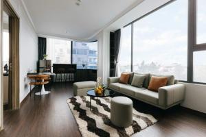 een woonkamer met een bank en een groot raam bij Ivy Luxury Hotel Ha Noi in Hanoi