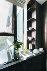 een aanrecht met een wastafel en een raam bij Ivy Luxury Hotel Ha Noi in Hanoi