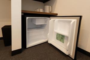 an empty refrigerator with its door open in a room at Port House Honmachi in Tokyo +10 photos