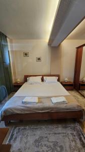 a bedroom with a large bed with two towels on it at Eva apartments in Mamaia +40 photos