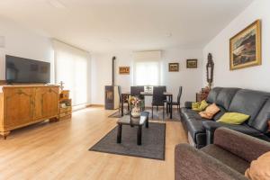 Una sala de estar con un sofá y un televisor. en Villa Soto de la Marina I Playas I Jardines, en Santa Cruz de Bezana