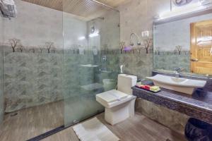 a bathroom with a shower and a toilet and a sink at Grand Krisa Resort & SPA, Manali Experience Luxury With all Weather ACs in Every Room in Manāli +57 photos