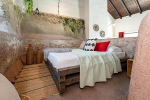 NunziataにあるVilla Nature & Relax Taorminaのベッドルーム1室(白いシーツと赤い枕のベッド1台付)