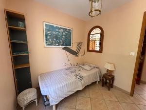 a bedroom with a bed and a window at L'Amandiers en Fleurs - Située à deux minutes des plages in Fouras