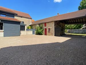 un edificio con garage e vialetto di Le Clos de Joux - Charmante Maison en Bourgogne a Joux-la-Ville