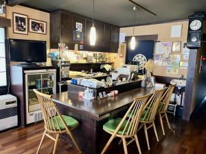 a kitchen with a counter with chairs and a bar at Henmi Ryokan in Hakodate
