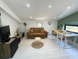 a living room with a couch and a table at Atypique T2 Cosy Genay in Genay