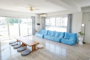 a living room with a blue couch and a table at ハレルヤ石垣 in Ishigaki Island
