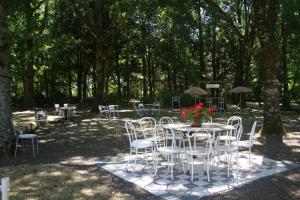 a group of tables and chairs in a park at Roulotte de charme in Bazauges