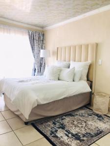 a bedroom with a large bed with a large window at Blanc and Bold in Vosburg