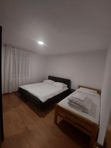 a bedroom with two beds and a table in it at Apartman Delminium in Tomislavgrad