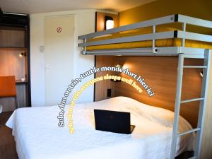 a bedroom with a bunk bed with a laptop on it at Premiere Classe Rodez in Rodez