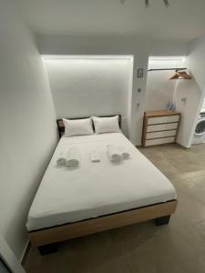 een slaapkamer met een bed met twee slippers erop bij Central Studio next to Metro in Piraeus