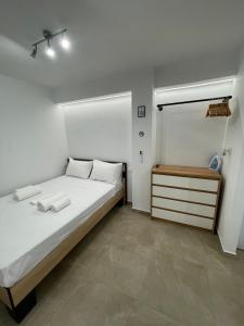 een slaapkamer met een groot wit bed en een dressoir bij Central Studio next to Metro in Piraeus