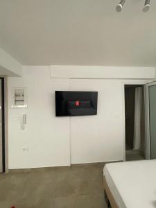 een kamer met een tv aan een witte muur bij Central Studio next to Metro in Piraeus +2 foto's