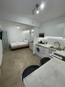 een keuken met een wastafel en een tafel en stoelen bij Central Studio next to Metro in Piraeus