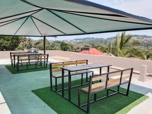 a couple of tables and benches under a tent at Jengel Two Bedroom Apartments Entebbe 1 in Entebbe