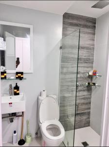 a bathroom with a toilet and a glass shower at JKVacation Home in Tacondo
