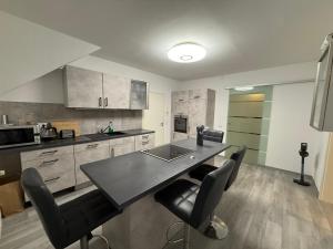 a kitchen with a table and black chairs in it at Guestroom K17 in Thale