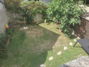 un piccolo cortile con un tosaerba nell'erba di Longère Tourangelle Le Buissonnet a Azay-sur-Cher